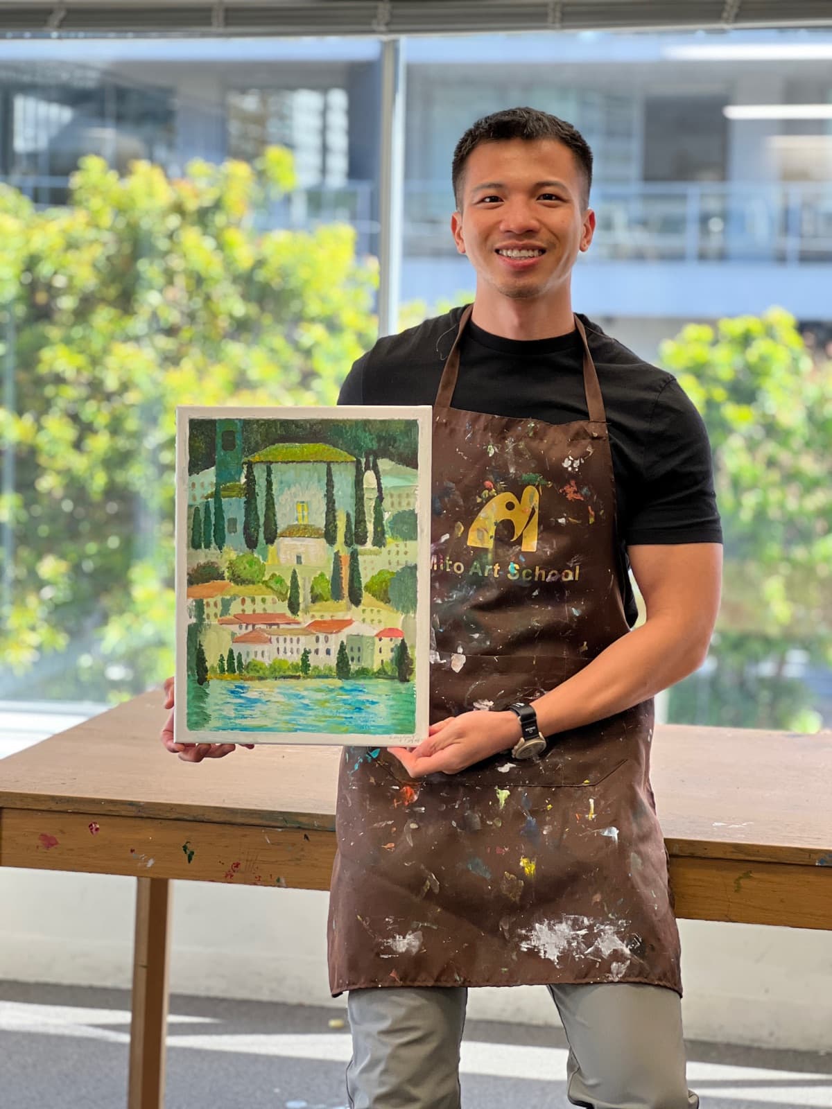 Raygar holding a painting at art school